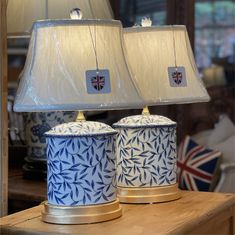 two blue and white lamps sitting on top of a wooden table next to each other