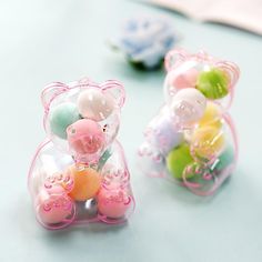 two small plastic pig figurines sitting next to each other on top of a table