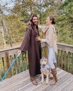 a man and woman dressed up as star wars characters on a deck with a dog