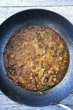 a skillet filled with food on top of a wooden table