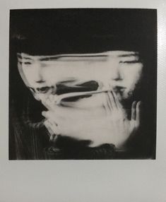 a black and white photo of a person with their face obscured by a glass bowl