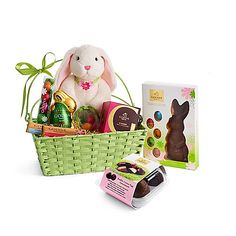 a basket filled with chocolates and a stuffed bunny sitting next to it's packaging