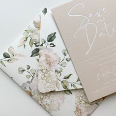 the wedding stationery is laid out on top of each other with flowers and leaves