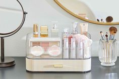 an organized makeup organizer sits on a desk in front of a mirror and vanity mirror