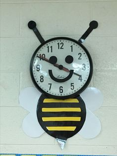 a black and yellow clock with a bee on it