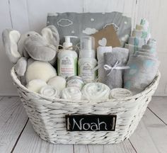 a basket filled with lots of baby items on top of a white wooden floor next to a wall