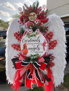 a christmas angel decoration with red and white decorations on it's wings, saying cardinals appear when angels are near