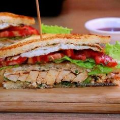 a cut in half sandwich sitting on top of a wooden cutting board