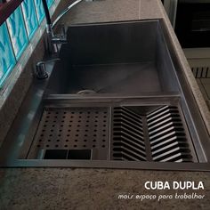 a stainless steel kitchen sink with drain and strainer grates on the countertop