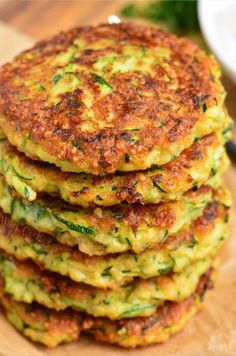 a stack of zucchini fritters sitting on top of a wooden cutting board