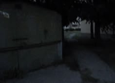 a blurry image of an alley way at night with no one on the sidewalk