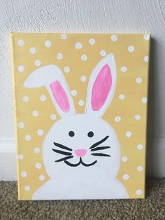 a painting of a white rabbit with pink ears and polka dots on a yellow background