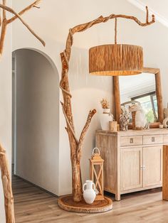 a living room filled with furniture and a large wooden tree next to a mirror on the wall