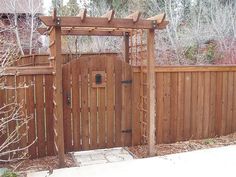 a wooden gate in front of a fence