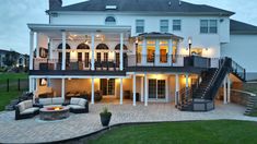 a large white house with stairs leading up to the upper floor and second story area