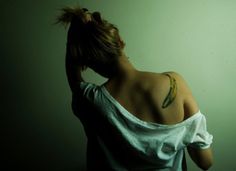 the back of a woman's head with a banana tattoo on her left shoulder