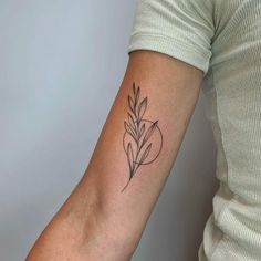 a woman's arm with a small flower tattoo on the left side of her arm