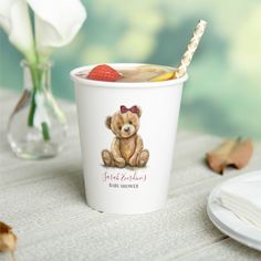 there is a cup with a straw in it and a teddy bear on the side