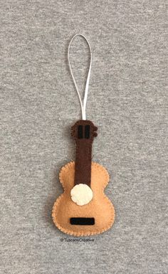 a felt ornament hanging from a string on top of a gray sweater shirt