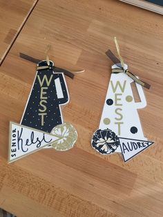 two wooden signs are hanging on a wood table with ribbon and tags attached to them