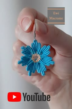 a person is holding a small blue flower in their hand with the words ewi marerame on it