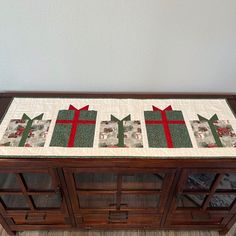 a wooden cabinet with a quilted christmas present on it's top and bottom