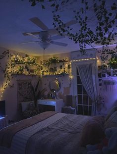 the bedroom is decorated with plants and fairy lights on the ceiling, along with other decorations