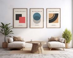 three framed art prints hang on the wall above two couches and a coffee table