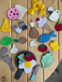 several felt appliques laid out on a table with utensils and spoons