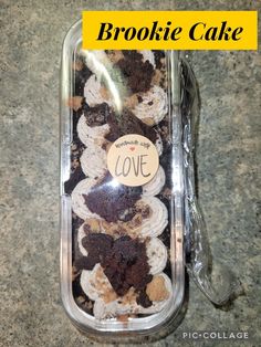 a plastic container filled with cookies on top of a granite counter next to a yellow sign