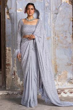 Grey georgette saree with self and silver bead work , sequins and crystals with feather fringes. Paired with full sleeve organza blouse and petticoat.
Components: 3
Pattern: Embroidered
Type Of Work: Sequin, Bead, Crystals
Neckline: Square
Sleeve Type: Full
Fabric: Saree: Pure Georgette and Blouse: Art Organza, Petticoat: Shantoon
Color: Grey
Other Details: 
Back tassel tie-up
Bead and crystal work
Occasion: Wedding,Reception - Aza Fashions Saree With Full Sleeves, Sequinned Saree, Full Sleeves Blouse, Full Sleeves Blouse Designs, Crystal Work, Pure Georgette Sarees, Silver Blouse, Grey Saree, Full Sleeve Blouse