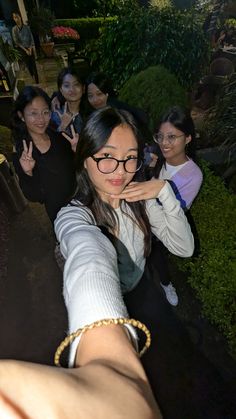 a group of women standing next to each other in front of a building at night