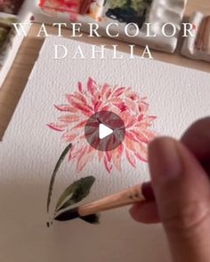 someone is painting watercolor dahlia on paper