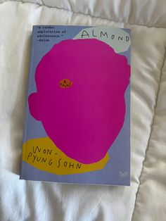 a pink flower on top of a white bed with the words almond written below it