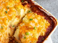 a casserole dish with meat and cheese in it on a white platter