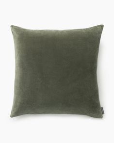 a green velvet pillow on a white background