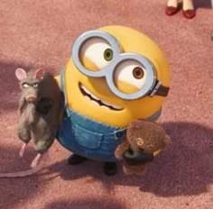 two small stuffed animals standing next to each other in front of a yellow and blue minion