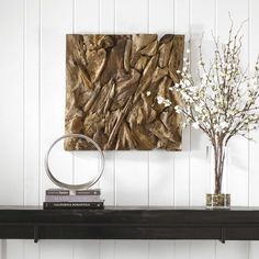 a table with some books and vases on top of it next to a painting