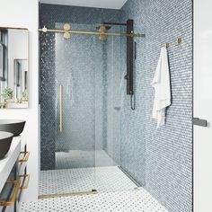 a bathroom with a glass shower door and white tile flooring on the walls, along with a gold framed mirror