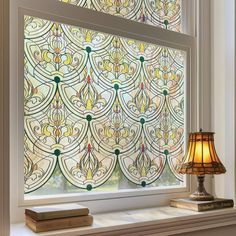 a stained glass window with a lamp next to it and a book on the windowsill