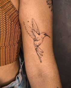 a couple of tattoos that are on their arms and legs, one with a hummingbird tattoo on it's arm