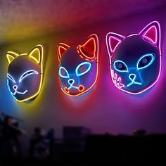 three neon cats are hanging on the wall