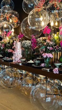 an assortment of vases and flowers on display in front of bubbles hanging from the ceiling