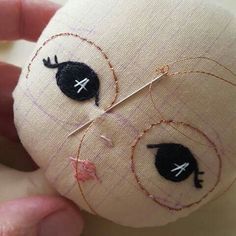 someone is stitching on the back of a stuffed animal