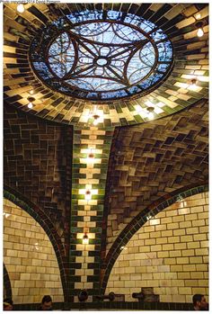 the inside of a building with tiled walls and a stained glass window in the ceiling