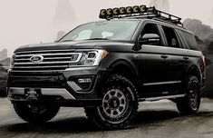 a black ford expedition vehicle parked in front of mountains