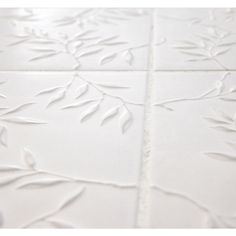 a white tile floor with leaves drawn on it