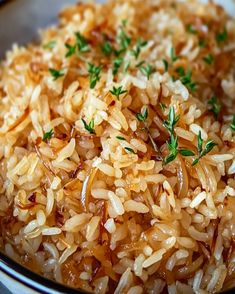 a bowl filled with rice and garnished with parsley on top, sitting on a table