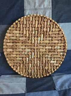 a wooden plate made out of wine corks on a blue and white checkered cloth