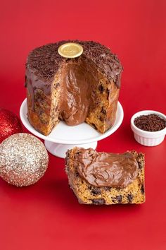 a cake with chocolate frosting sitting on a plate next to two pieces of cake